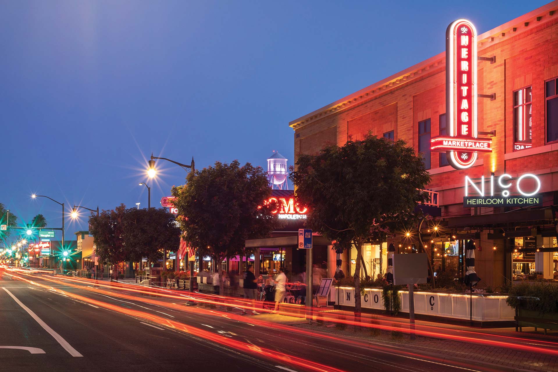 The vibrant neon lights of Gilbert's Heritage District invite families for an unforgettable evening.